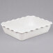 A white rectangular dish with a scalloped edge.