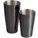 A black cylindrical container with two stainless steel cups inside.