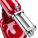 A red KitchenAid mixer with metal attachments.