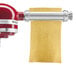 A KitchenAid pasta roller with a red handle.