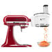 A KitchenAid stand mixer with the Continuous Feed Food Processor attachment.