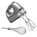A KitchenAid Contour Silver hand mixer with stainless steel whisk and beaters.