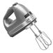 A KitchenAid contour silver hand mixer with a whisk attachment.