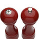 Two Chef Specialties candy apple red pepper mills with a salt shaker on top.