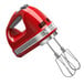 A red KitchenAid hand mixer with silver accents.