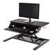 A Luxor black two-tier stand up desktop desk with a computer on it.