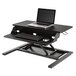 A black Luxor stand up desktop desk with a laptop and keyboard on top.