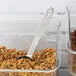 A Vollrath stainless steel measuring spoon in a container of cereal.
