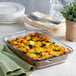 An Anchor Hocking clear glass baking dish filled with spinach and cheese casserole on a table.