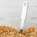 A Vollrath stainless steel measuring scoop with granola in a container.