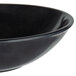 A close-up of a black bowl with a white rim.