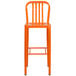 An orange metal bar stool with a vertical slat back and legs.