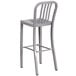 A silver metal bar stool with a backrest.