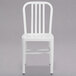 A white metal Flash Furniture chair with a grey background.