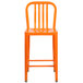 An orange metal counter height stool with a vertical slat back on a white background.