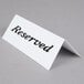 An American Metalcraft plastic table tent with the word "Reserved" in black on a white card.