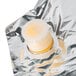 A plastic cap on a silver foil bag of Gehl's Sharp Cheddar Cheese Sauce.