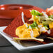 A plate of nachos with tortilla chips and Gehl's Jalapeno Cheese Sauce on a table.