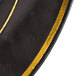 A close up of a Fineline black plastic plate with gold bands.