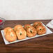An American Metalcraft melamine platter with a plate of bagels on a table.