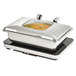 A Vollrath stainless steel chafing dish with food inside on a counter.