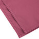 A folded pink Intedge cloth napkin.