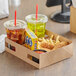 A Kraft paper tray with chicken nuggets and chips and a plastic cup with a straw in it, in a box.