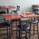 A Lancaster Table & Seating butcher block table with chairs and glasses on it