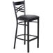 A Lancaster Table & Seating black metal cross back bar stool with black cushion.
