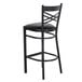A black Lancaster Table & Seating cross back bar stool with a black cushion.