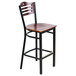 A Lancaster Table & Seating black bistro bar stool with mahogany wood seat and back.