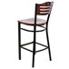 A Lancaster Table & Seating black bistro bar stool with a mahogany wood seat and back.