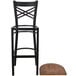A Lancaster Table & Seating black metal barstool with a wood seat.