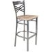 A Lancaster Table & Seating metal bar stool with a driftwood seat.