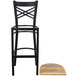 A Lancaster Table & Seating black cross back bar stool with a driftwood seat next to a wood floor.