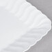 A white Fineline Flairware plastic snack tray with a wavy edge.