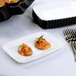A white Fineline Flairware plastic snack tray with a small dish of food and silverware.