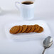 A white Fineline Flairware snack tray with brown cookies and a white mug with brown liquid on it.