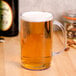 A GET plastic beer mug filled with beer on a table.