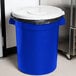 A blue trash can with a white lid.