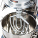 A Vollrath flat beater attached to a mixer with a bowl inside.
