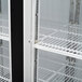 A white Turbo Air glass door merchandising freezer with black shelves.