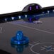 A blue Lumen-X air hockey table with a blue puck.