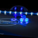 A Triumph Lumen-X Lazer air hockey table with blue lights.