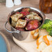 An American Metalcraft stainless steel pot filled with potatoes and broccoli on a table.
