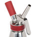A close up of a stainless steel iSi decorating tip with red plastic accents.