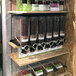 A shelf with Rosseto DSM400 dispensers holding different types of beans.