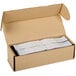 A burgundy cardboard box with several rolls of white paper napkin bands.
