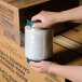 A hand holding a roll of 5" x 1000' stretch banding film.