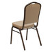 A Flash Furniture tan vinyl banquet chair with a metal frame and cushion.
